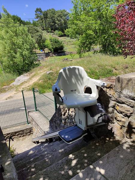 monte escalier droit extérieur installé sur mur en pierre