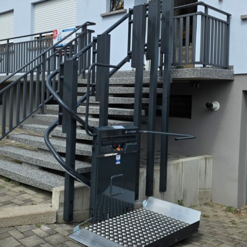 vue de face de la plateforme Lehner installée en bas des marches extérieures, plateau déroulé au niveau du sol, escalier en granit et garde-corps anthracite en arrière-plan