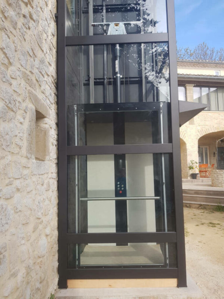 vue de l'intérieur de la cabine, porte ouverte sur la façade en pierre