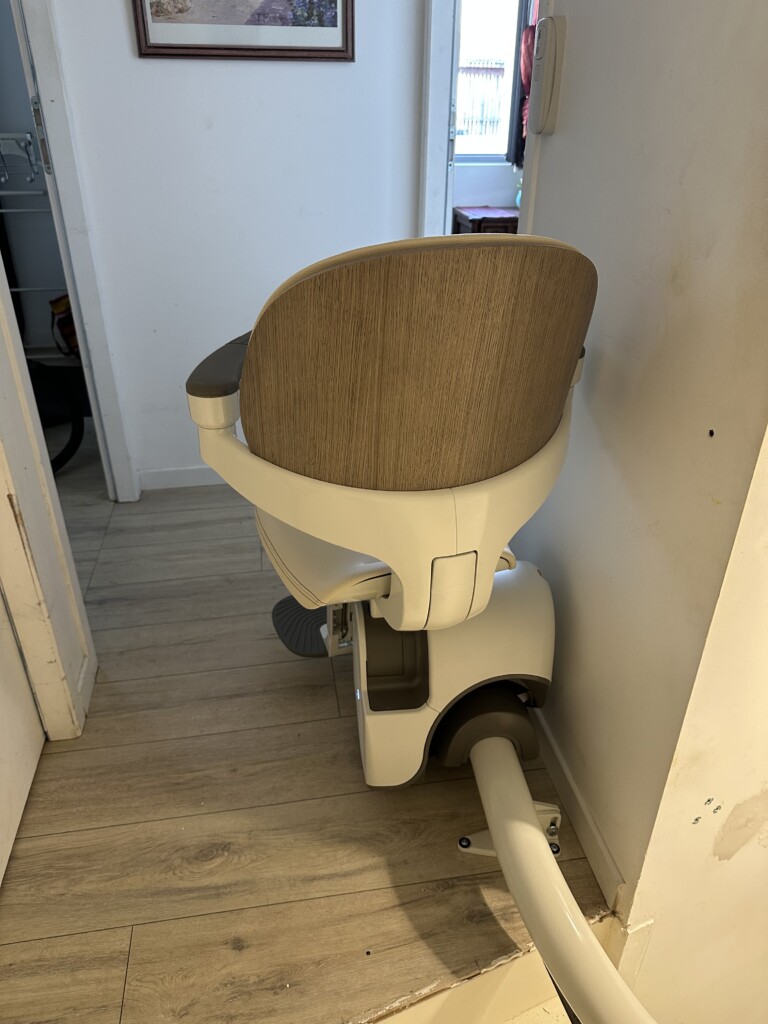 vue de dos du fauteuil, dossier effet bois chêne clair, bas d'escalier, parquet blond