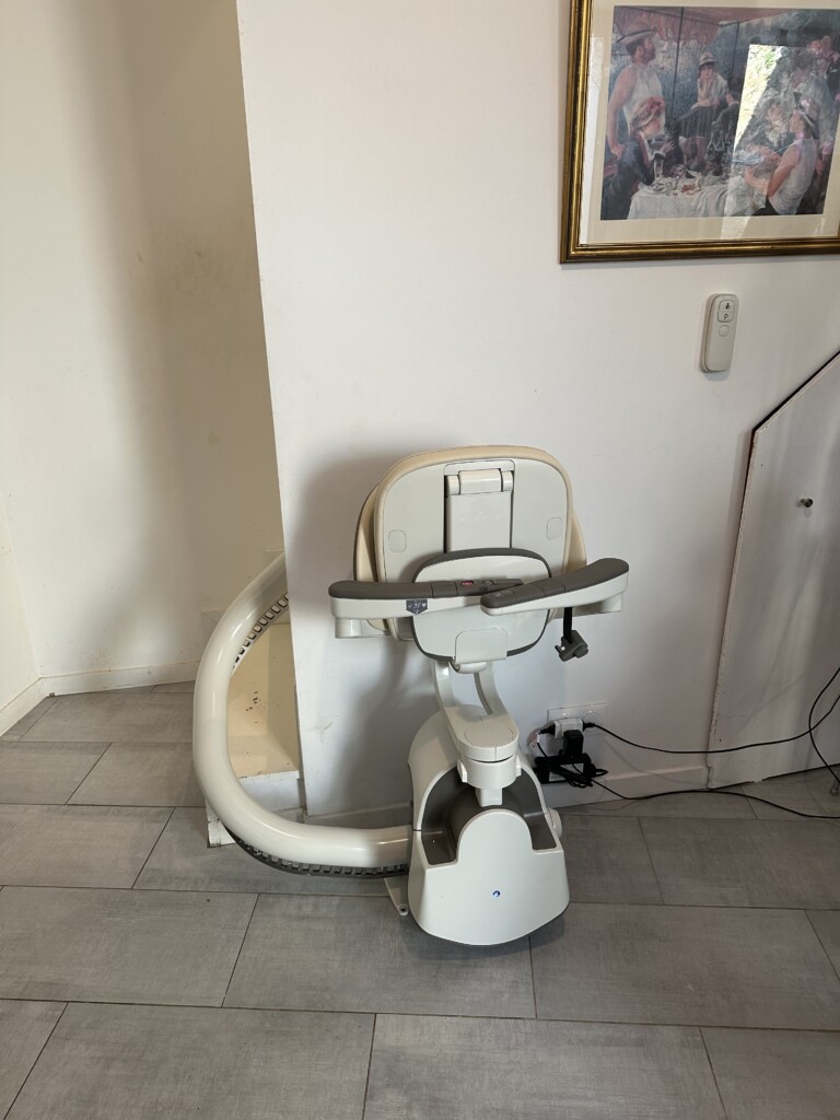 vue de face, fauteuil crème, accoudoirs fermés, tableau classique en arrière-plan
